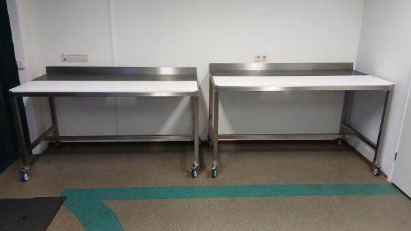 2 stuks verrijdbare RVS werktafels van verschillende hoogte.