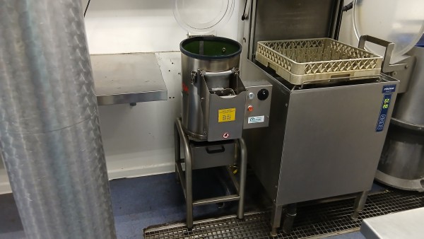 Omega 5 kg schrapmachine De Omega schrapmachine opgesteld tussen de werktafel en de vaatwasmachine.